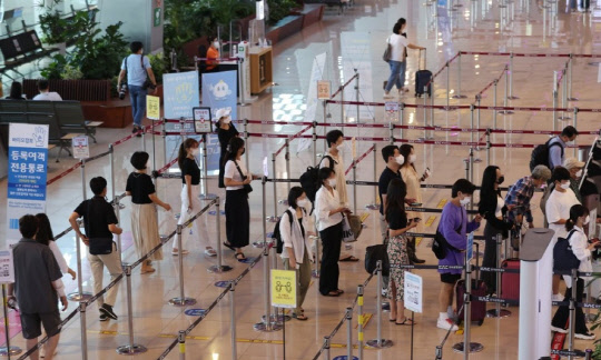지난 12일 오후 김포공항 국내선 청사에서 탑승수속을 마친 여행객들이 비행기 탑승을 위해 줄을 서 있는 모습. <연합뉴스>